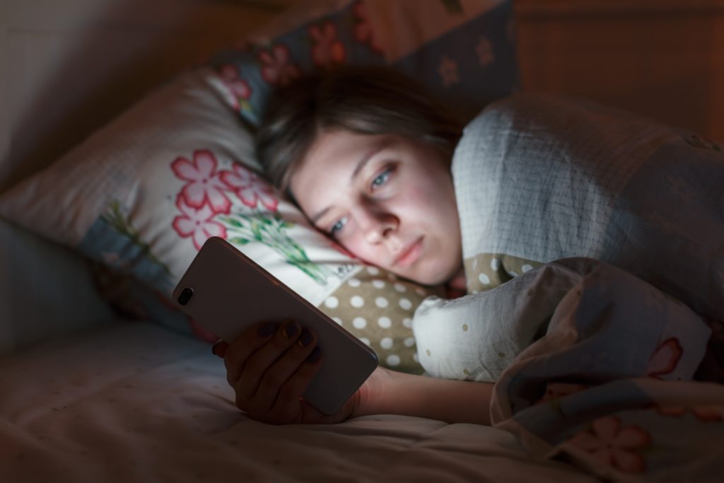 Woman Using Smartphone In Bed